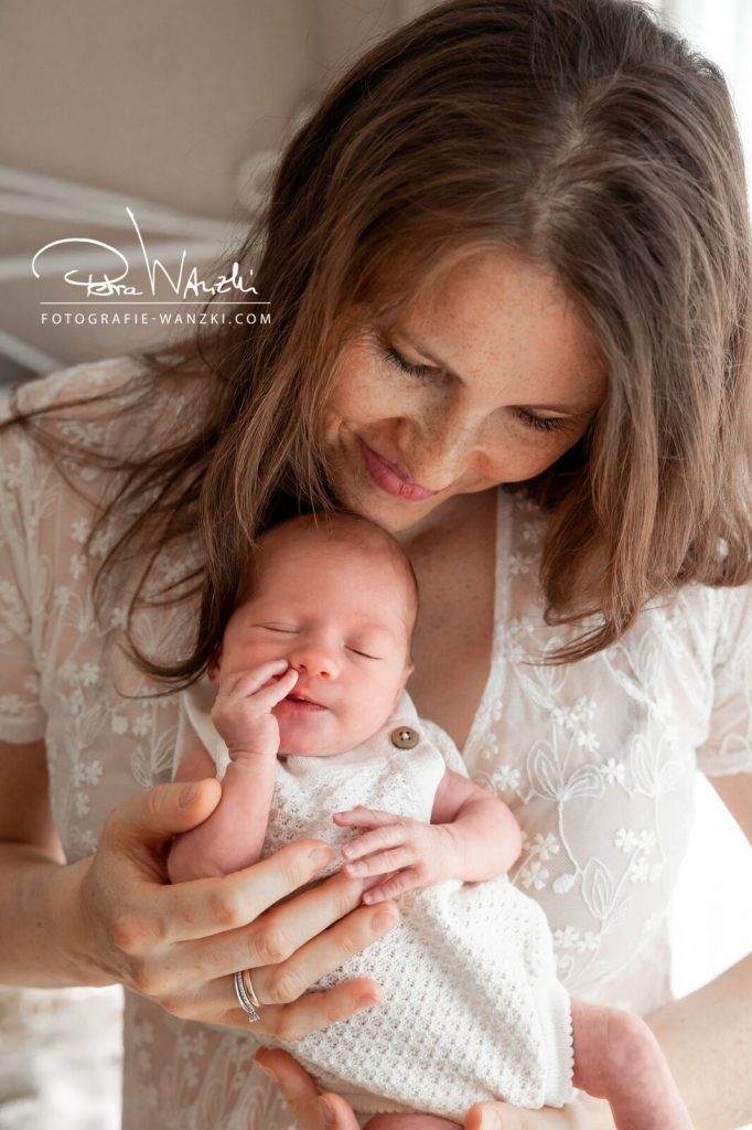 Baby kuschelt in Mamas Arm und wird sanft gehalten