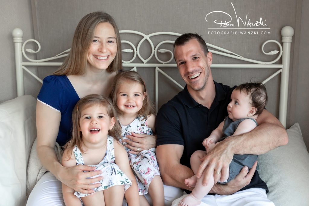 glückliche Familie mit 3 Kindern, Baby auf dem Arm