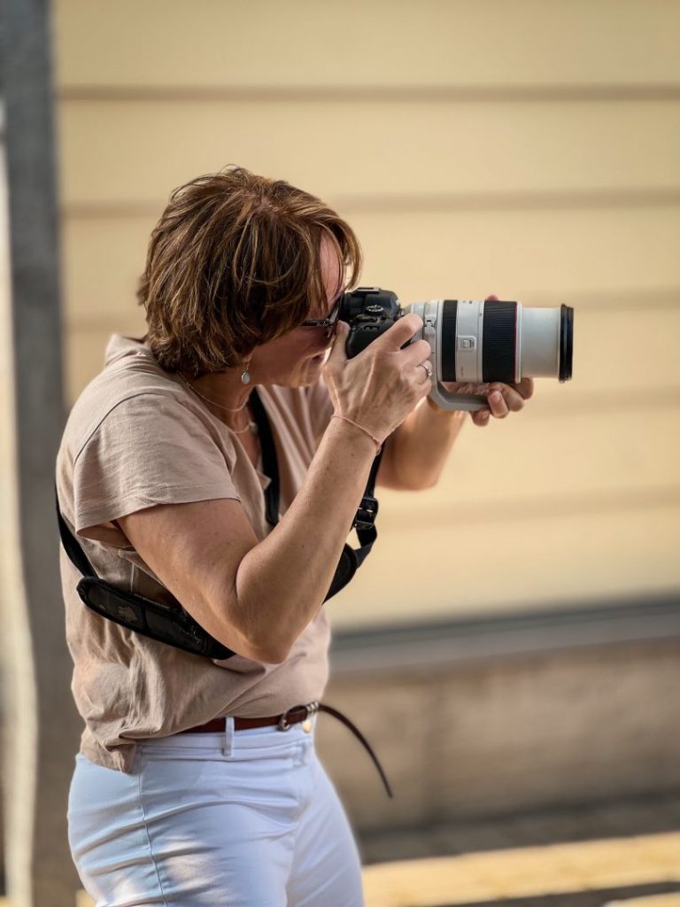 Fotografie Wanzki, Petra Wanzki beim Fotografieren, sie hält eine Canon EOS R II mit ZoomObjektiv in der Hand