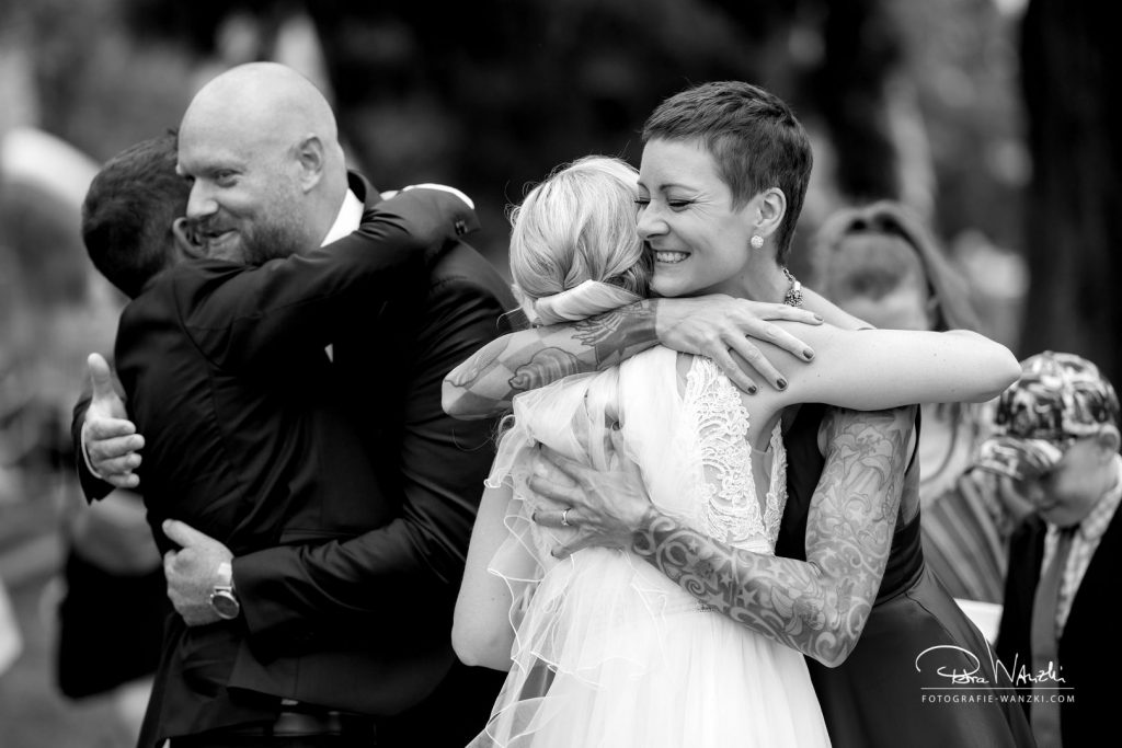 Beste Freundin umarmt Braut und gratuliert ihr bei der Hochzeit am Greifensee, Bild in schwarz weiss