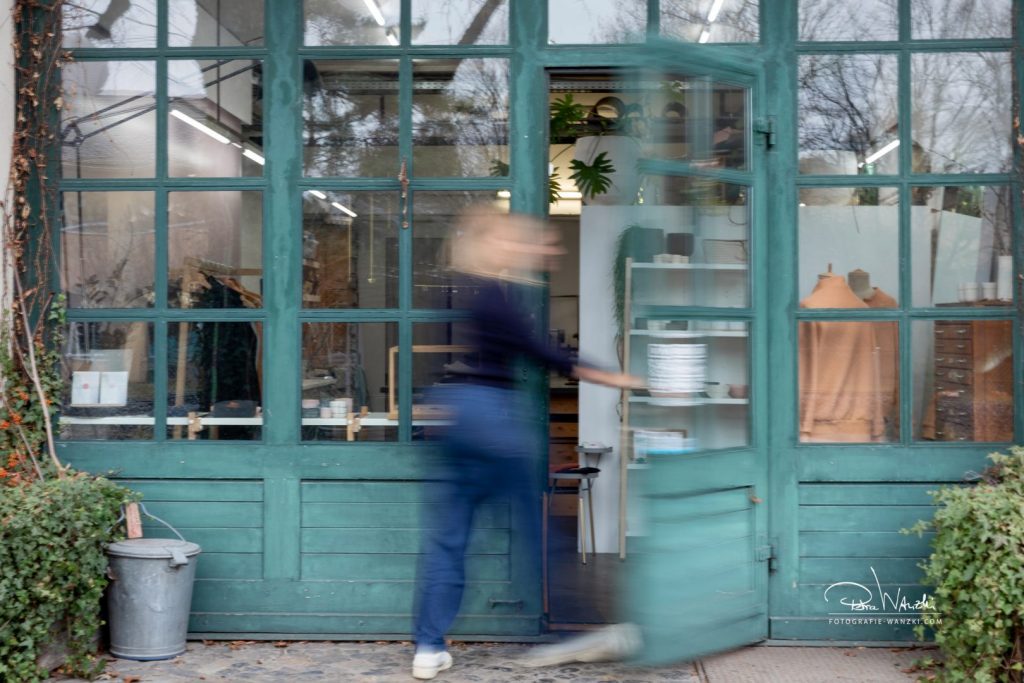 Frau geht durch die Tür eines Ateliers, Fassade im Industriestyle, Bewegungsunschärfe für das Business Portrait in Winterthur