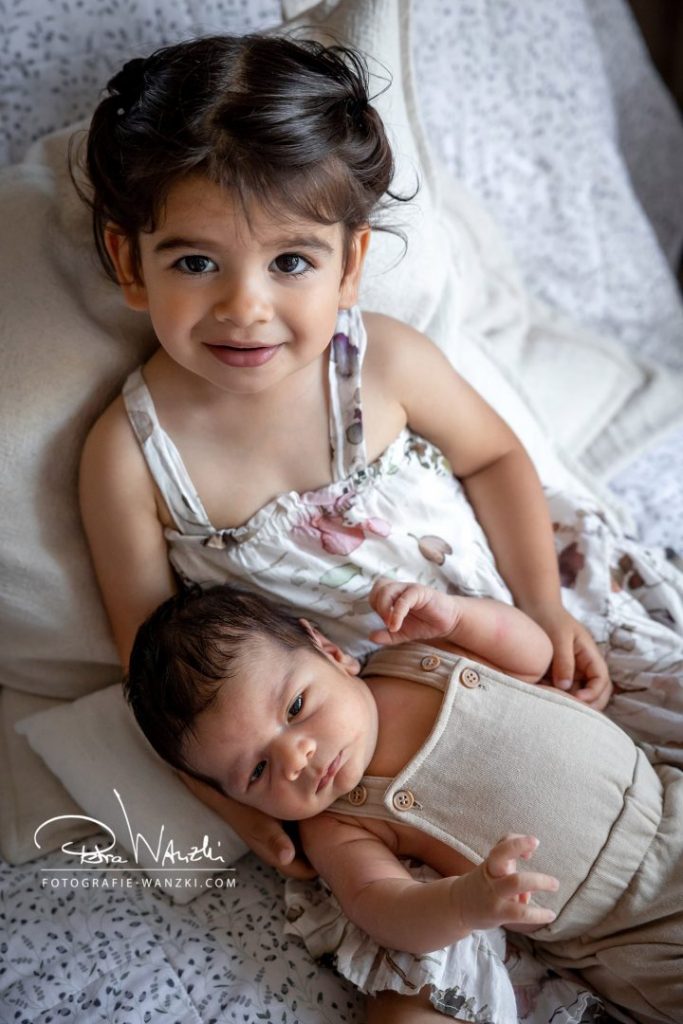 Baby FotoShooting im Studio in Winterthur, kleine Schwester hält ihren Bruder Baby im Arm