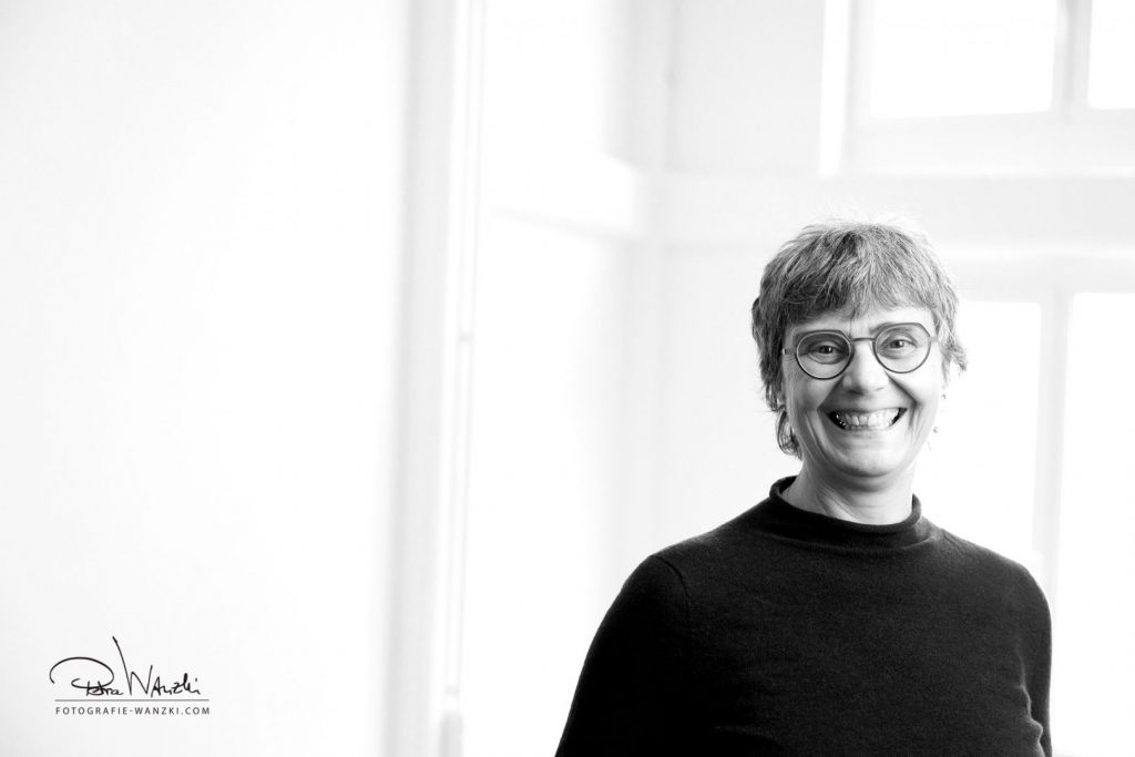 Business Portrati in Winterthur Zürich von einer lachenden Frau mit Brille vor einem Fenster