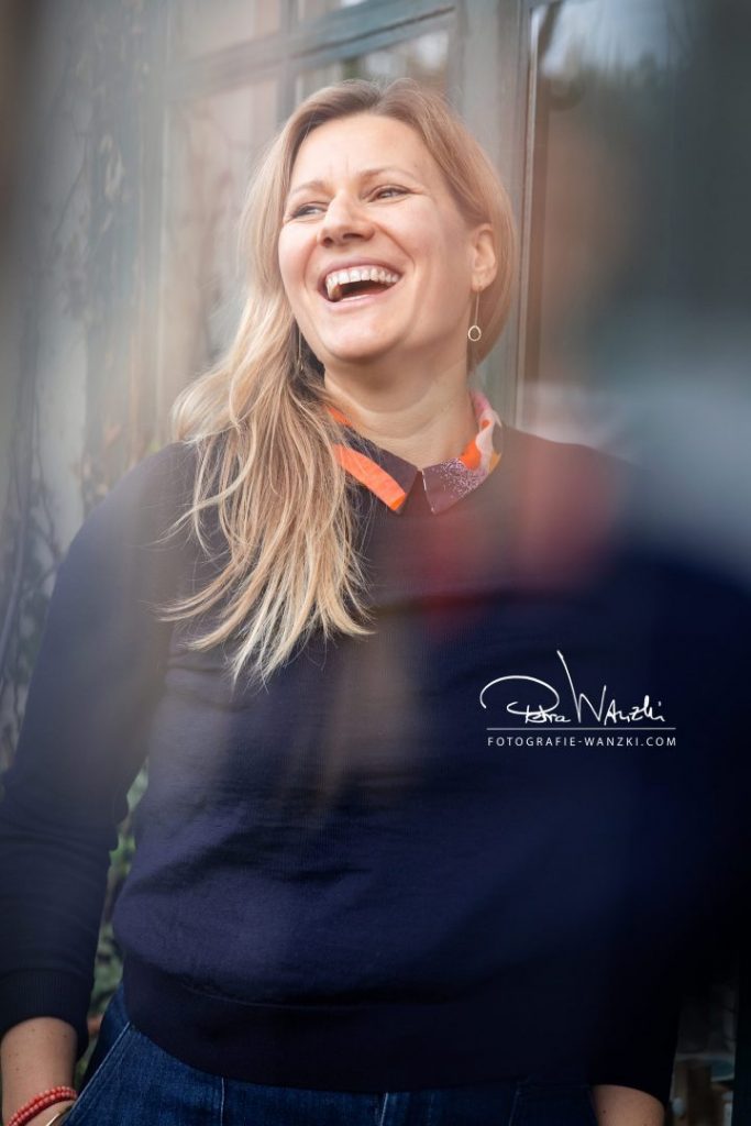 lachende Frau vor ihrem Atelier in Winterthur, sie schaut nach links