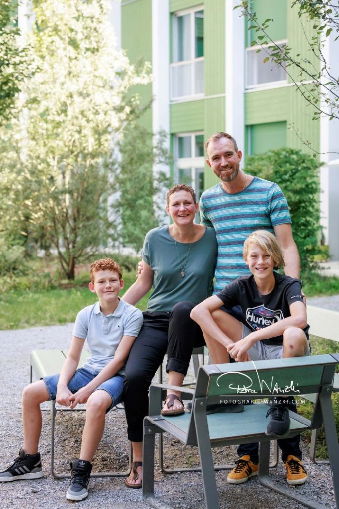 Familienportrait mit Teenager, alle sitzen auf Stühlen, urban, im Frühjahr