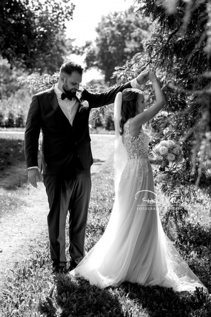 Brautpaar tanzt beim FotoShooting mit dem Hochzeitsfotograf in Winterthur, Braut dreht sich, Hochzeitskleid schwingt, Bild in schwarz-weiss