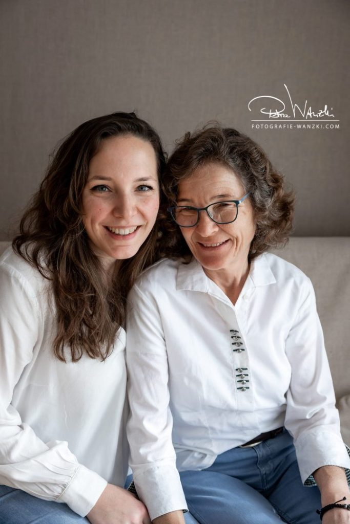 Mutter mit ihrer erwachsenen Tochter sitz auf dem Sofa